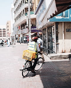 man in green high-visibility vest riding gray bike thumbnail