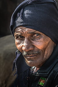 Man in Black Leather Jacket Wearing Black Cap in Close Up thumbnail