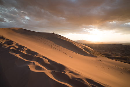 people walking on desert during daytime thumbnail
