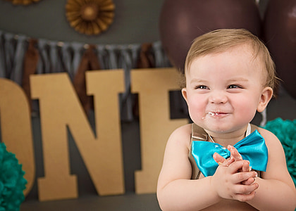 baby wearing brown top with blue bow tie accent thumbnail