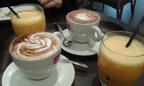 two white ceramic teapots filled with cappuccino coffe thumbnail