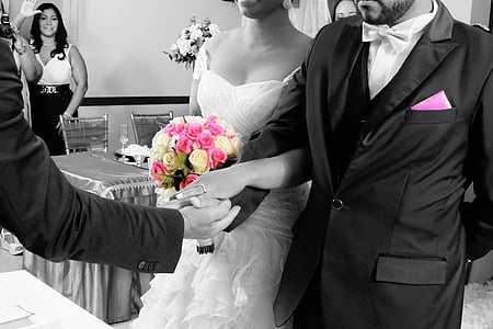 selective color photography of bride and groom holding white and pink rose flowers bouquet thumbnail