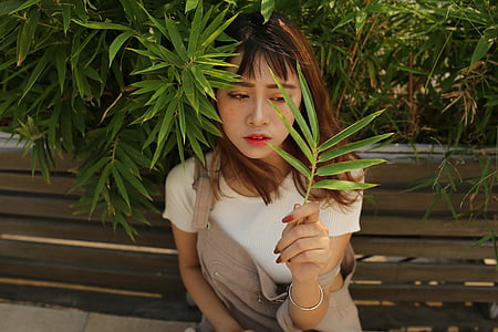 woman holding green leaf thumbnail