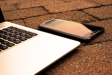black smartphone beside laptop thumbnail