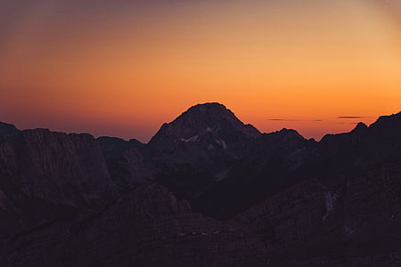 black mountain range with sunlight glaring on rocks thumbnail
