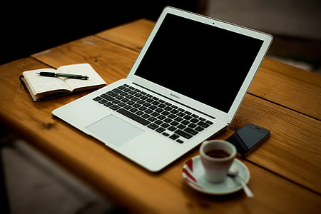 turned-off MacBook Air on brown wooden surface thumbnail