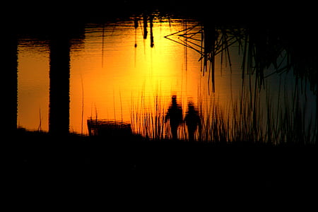 silhouette of man and woman near body of water thumbnail