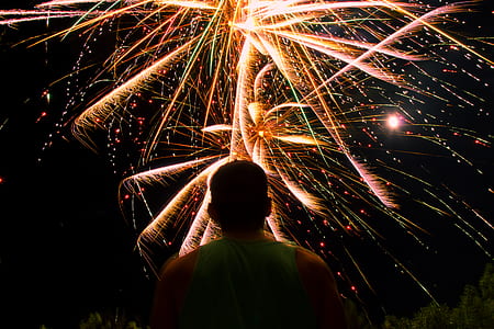 man standing facing upward looking fireworks thumbnail