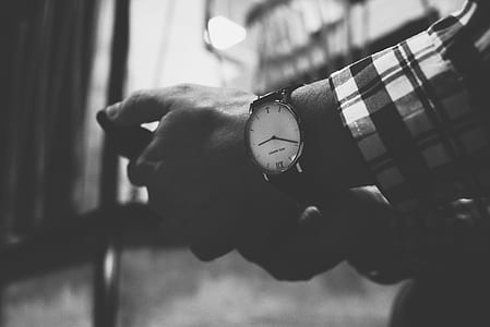 grayscale photo of person wearing analog watch thumbnail