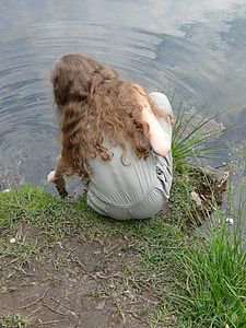 woman in grey rompers sitting bedside river during daytime thumbnail