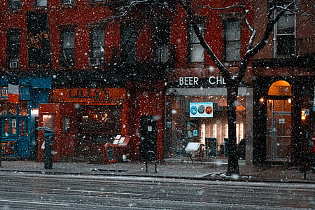 photo of building with lights on during snow fall thumbnail