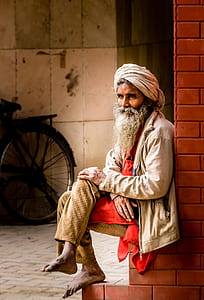 man sitting on brick wall thumbnail