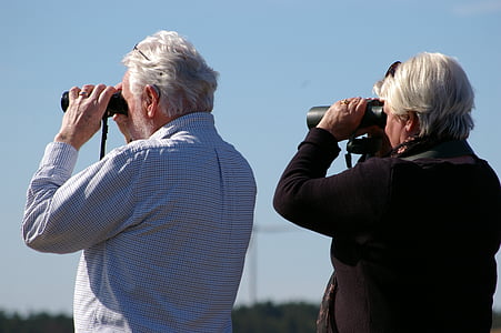 woman and man looking using binoculars thumbnail