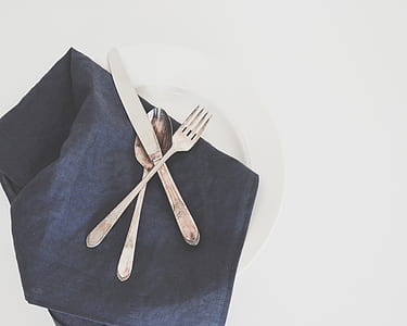 silver kitchen knife, fork, and spoon on plate thumbnail
