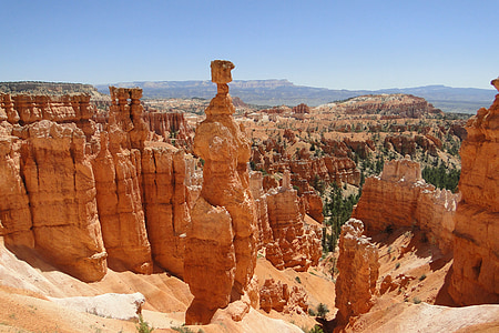 brown rock formation overlooking plains under blue sky thumbnail