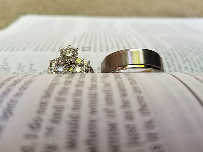 two silver-colored rings on open book thumbnail