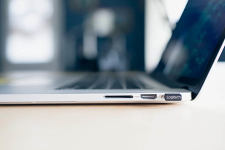 MacBook Side view with USB, HDMI, and SD Card Inputs. Apple MacBook on Wooden Table with blur Background. thumbnail