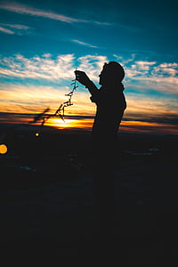 silhouette of person holding LED string lights thumbnail