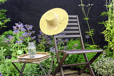 beige sun hat on brown wooden chair near glass thumbnail