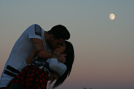 man in white crew-neck shirt kissing woman on white long sleeve top under last first quarter moon thumbnail
