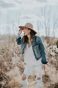 woman holding brown sun hat thumbnail