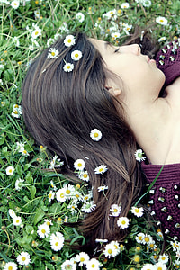 woman wearing purple top leaning on bed of Daisy thumbnail