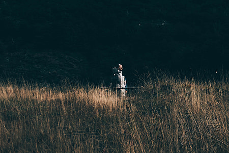 person standing near brown grass field thumbnail