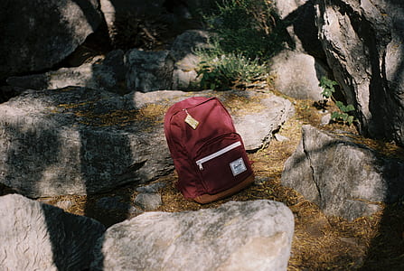 red backpack on top of boulder thumbnail