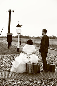 gray scale photo of couple with their luggage bags along the high way thumbnail