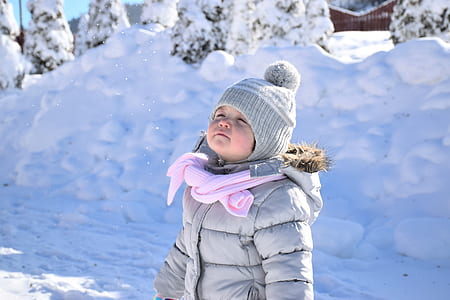 girl wearing gray puffer hooded jacket and knitted bobble hat thumbnail