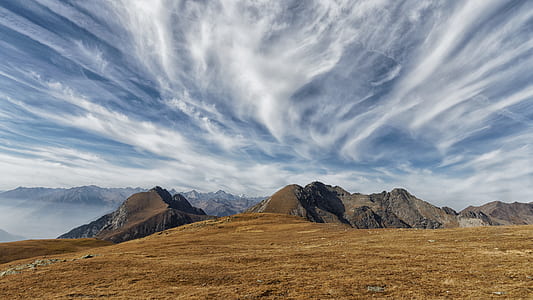 barren land formation near body of water under white clouds thumbnail