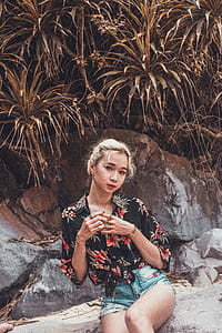 Woman Sitting Near Linear Leafed Plants thumbnail