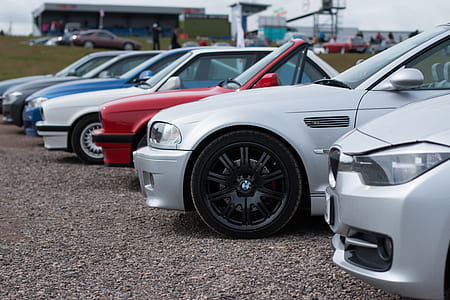 assorted-color BMW vehicles parked diagonal during daytime thumbnail