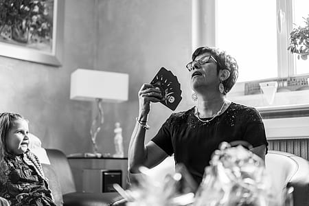 woman sitting while holding playing cards thumbnail
