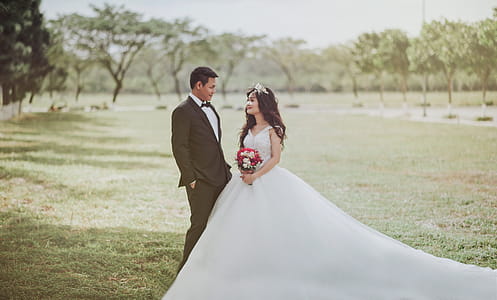 Woman Wearing Wedding Dress Standing Beside a Man Wearing Tuxedo thumbnail