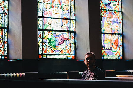 man sitting inside church near wall thumbnail