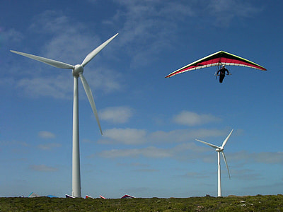 man riding on kite and view of two wind turbines thumbnail