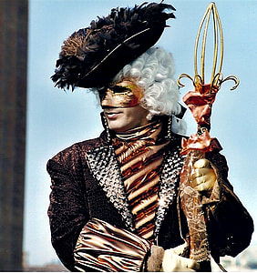 man wearing black and brown coat holding brass-colored decor thumbnail