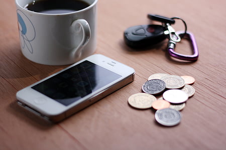 white iPhone 4 beside white ceramic mug filled with black liquid thumbnail