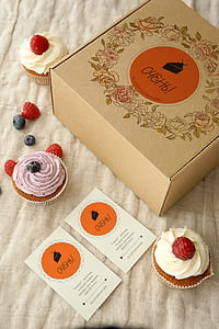 three cupcakes beside box on cloth thumbnail