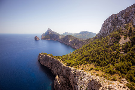 green and brown mountain near sea thumbnail