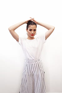 woman wearing white short-sleeved shirt and black and white striped bottoms thumbnail