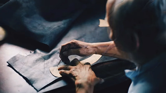 man cutting black textile thumbnail