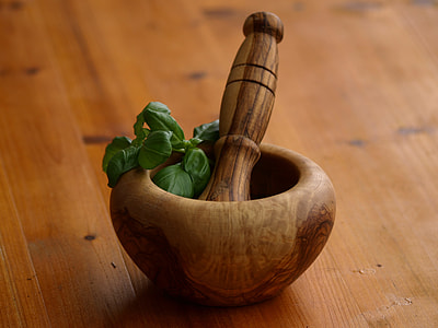 green herb on a brown wooden mortar and pestle thumbnail