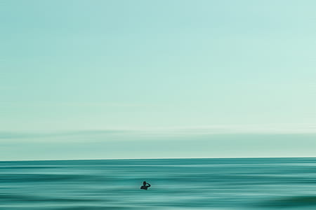 person swims on green ocean thumbnail
