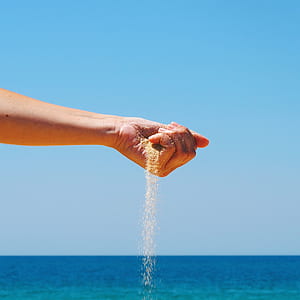 person pouring brown sand thumbnail