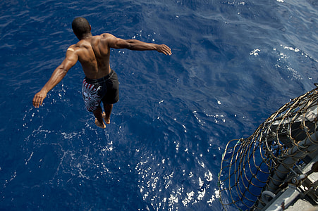 close up photo of topless man diving on body of water thumbnail
