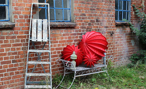 three red garden balls on bench thumbnail