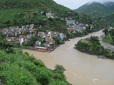 houses near river under white clouds thumbnail