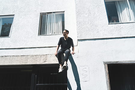 man sitting on terrace wearing black shirt thumbnail